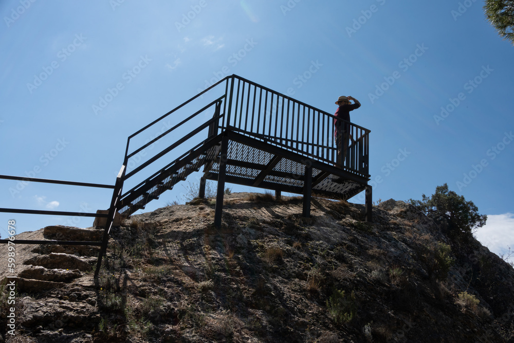 man in a splendour hat looking at the top of a tourist mountain ...