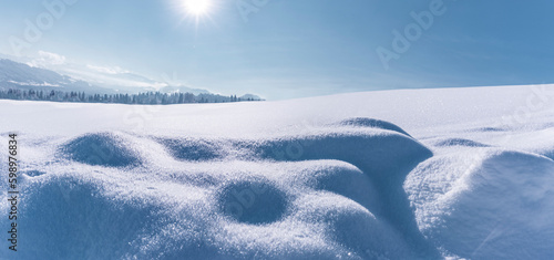 Verschneite Winterlandschaft mit schneebedeckten Tannenbäumen bei Sonnenlicht...