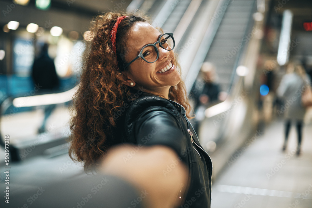 Laughing young woman leading someone along a metro platform Laughing young woman leading someone along a metro platform