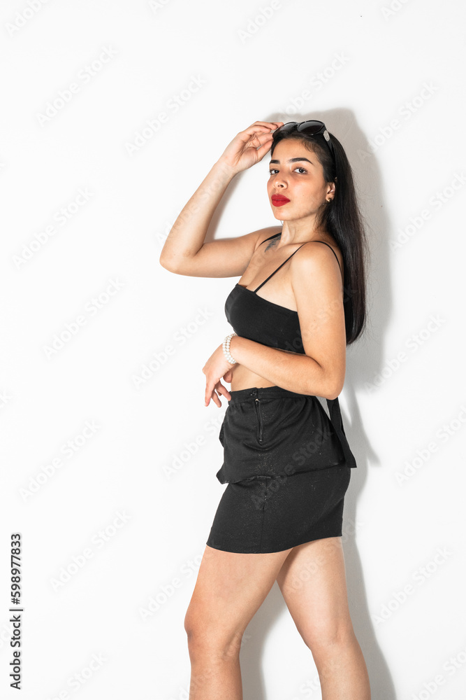 young brown-skinned latina woman posing sideways on a white background with one hand on her head young brown-skinned latina woman posing sideways on a white background with one hand on her head