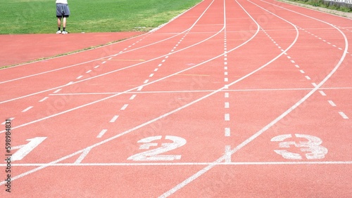 red running track start with starting numbers of running race between athletes in sport competition