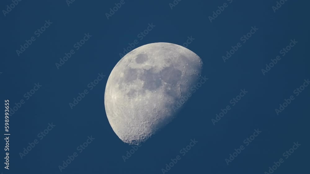 Bright full moon behind fast moving thin layer of clouds on night blue sky Bright full moon behind fast moving thin layer of clouds on night blue sky