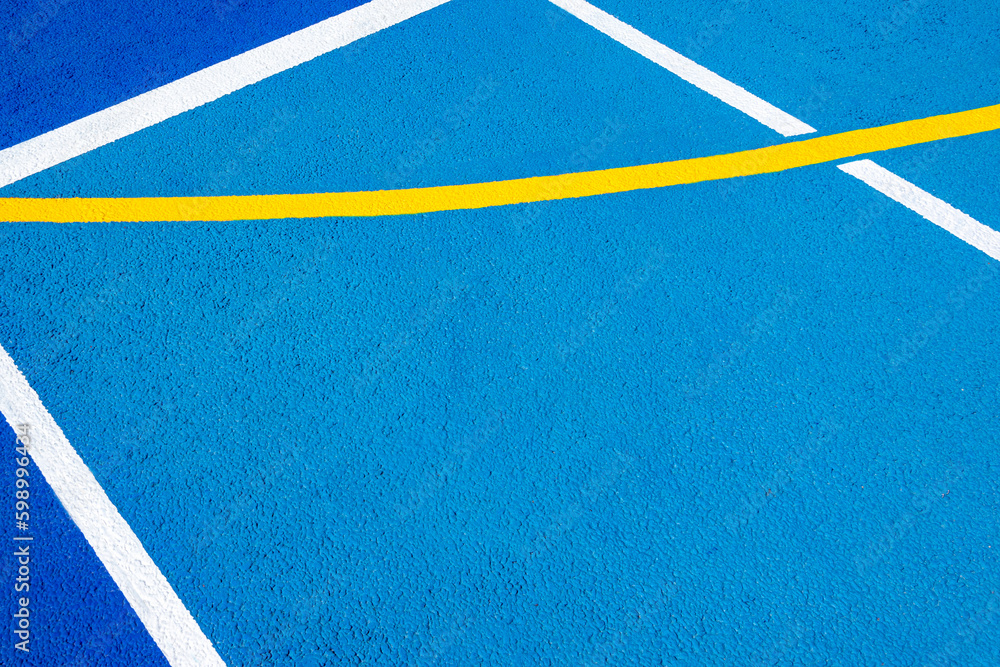 Sport field court background. Blue rubberized and granulated ground surface with white, yellow lines on ground. Top view