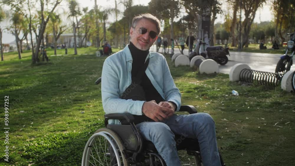 Portrait of the smiling happy man on a wheelchair wearing casual clothes. Disability and lifestyle concept. Portrait of the smiling happy man on a wheelchair wearing casual clothes. Disability and lifestyle concept.