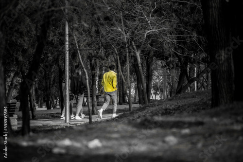 black and white photograph of a man in a yellow jacket in the park