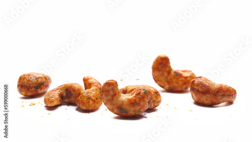 Spicy cashews nuts pile with chili isolated on white, side view