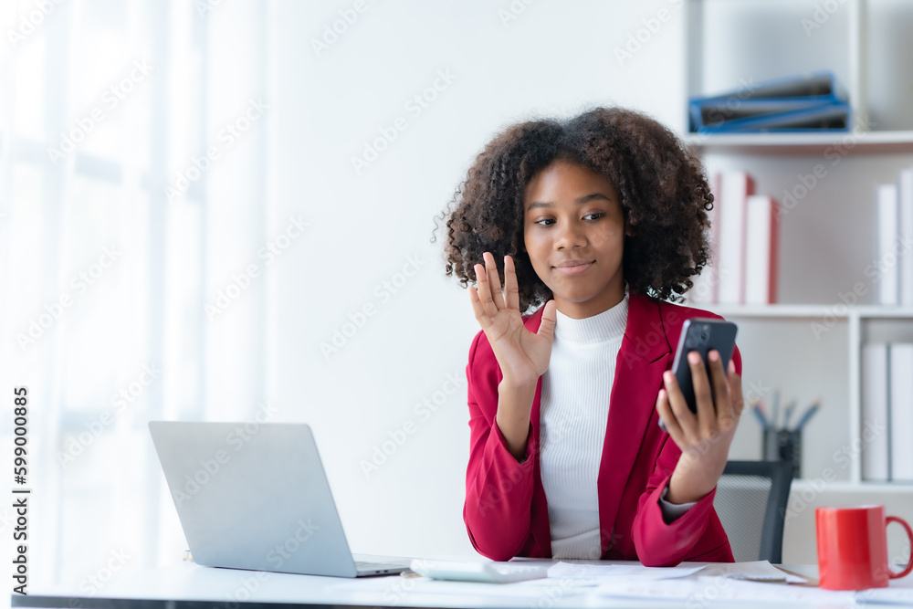 Beautiful young smiling businesswoman with curly hair a video call on smartphone. Beautiful young smiling businesswoman with curly hair a video call on smartphone.