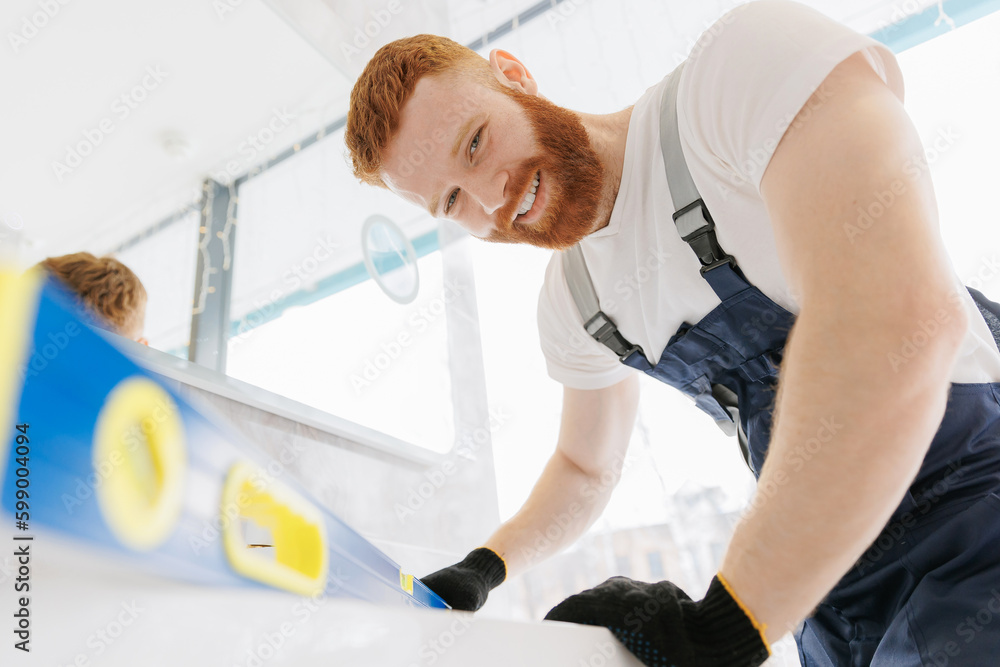 Man plumber installing white sink and control instal. Concept repair service plumbing in bathroom Man plumber installing white sink and control instal. Concept repair service plumbing in bathroom