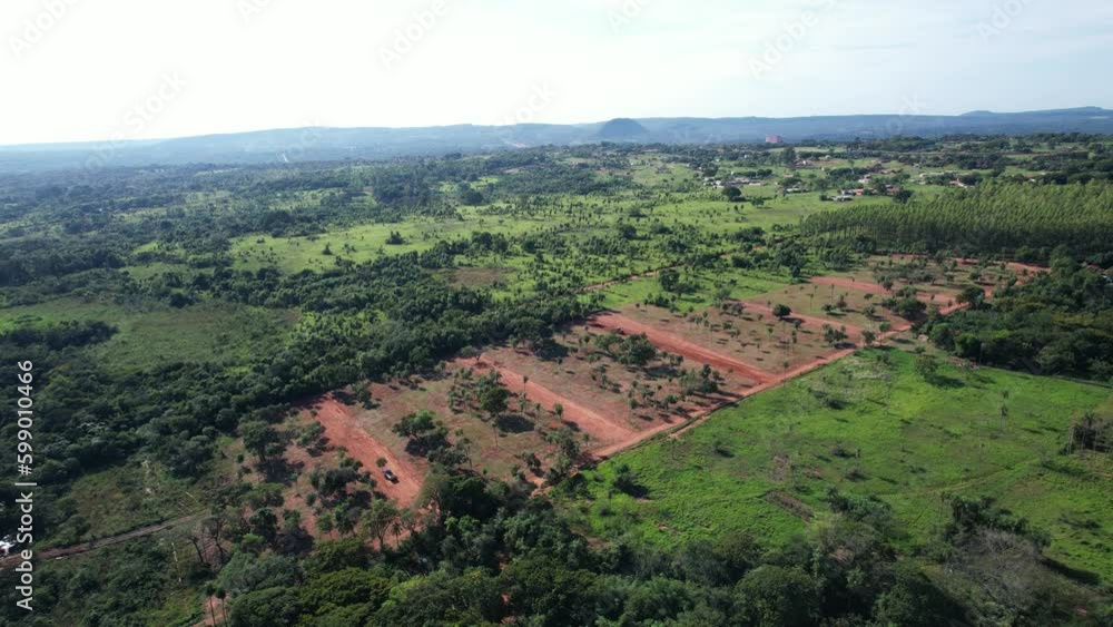 Aerial panoramic view of a natural landscape: field, forest and dirt terrain. Impressive aerial view. land surrounded by a field and a green forest. Natural beauty from above. a green landscape