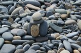 The tower is made of various pebbles on a stony beach.