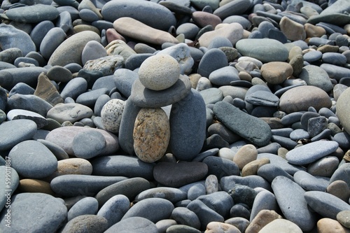 The tower is made of various pebbles on a stony beach.