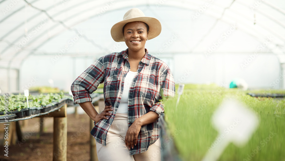 Portrait of a happy farmer in a garden. Young farmer standing in a greenhouse. African american farmer working in her garden. Proud farmer standing in her farm greenhouse