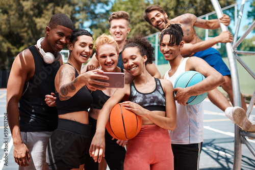 Fototapeta Naklejka Na Ścianę i Meble -  Gather around for a team selfie. a group of sporty young people taking selfies together on a sports court.