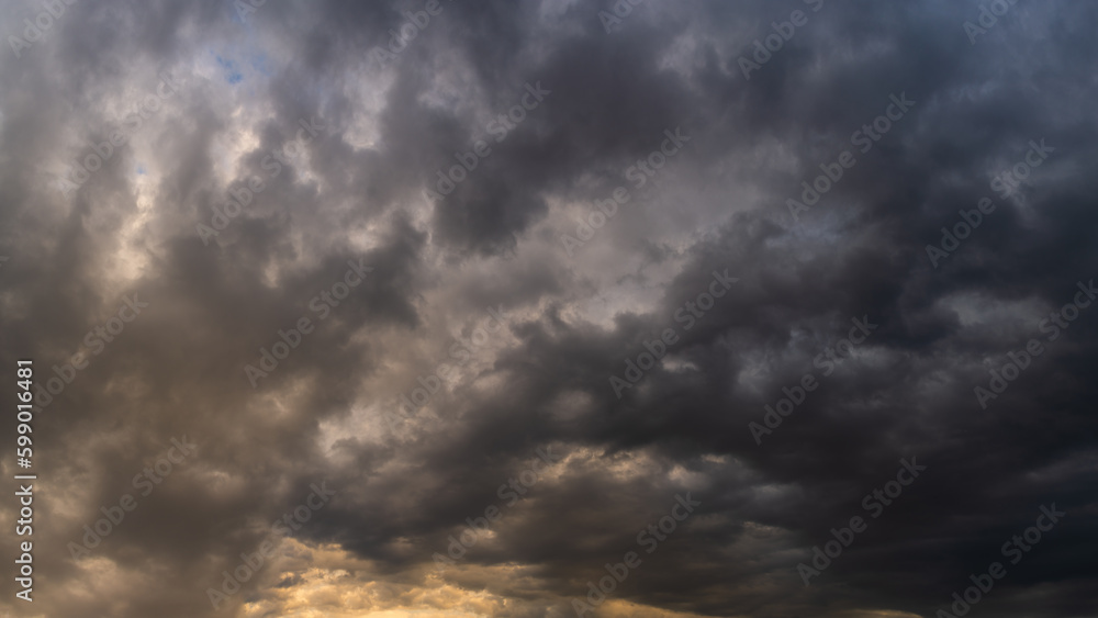Obraz premium stormy dramatic sky with dense rain clouds and backlight