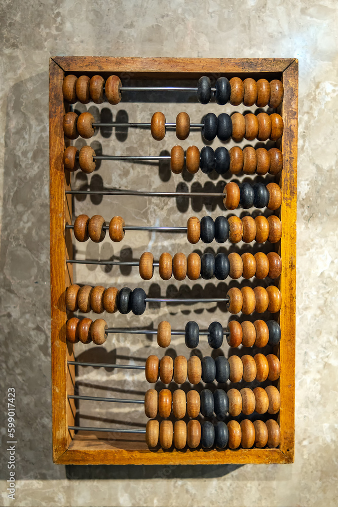 Hand wooden abacus lying on a stone table Hand wooden abacus lying on a stone table