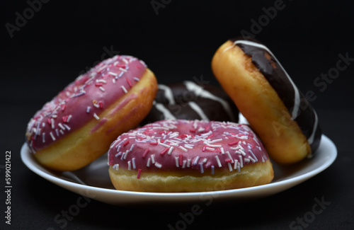 Delicious sweet donuts on a plate. Glazed doughnuts.