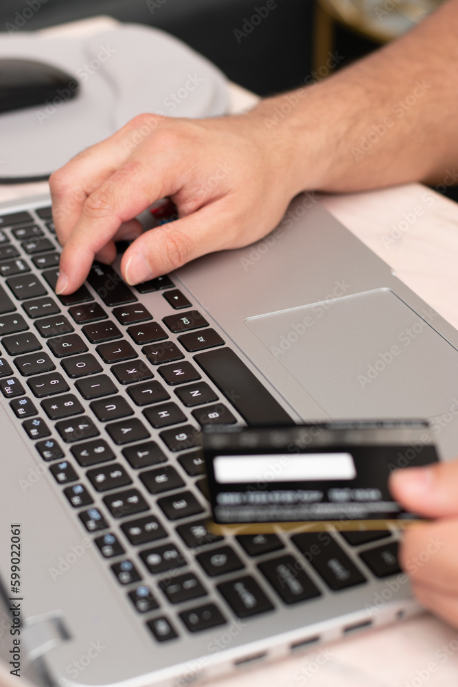 Vertical view of Person pushing Enter in the keyboard of the laptop confirm the online purchase with credit card Vertical view of Person pushing Enter in the keyboard of the laptop confirm the online purchase with credit card