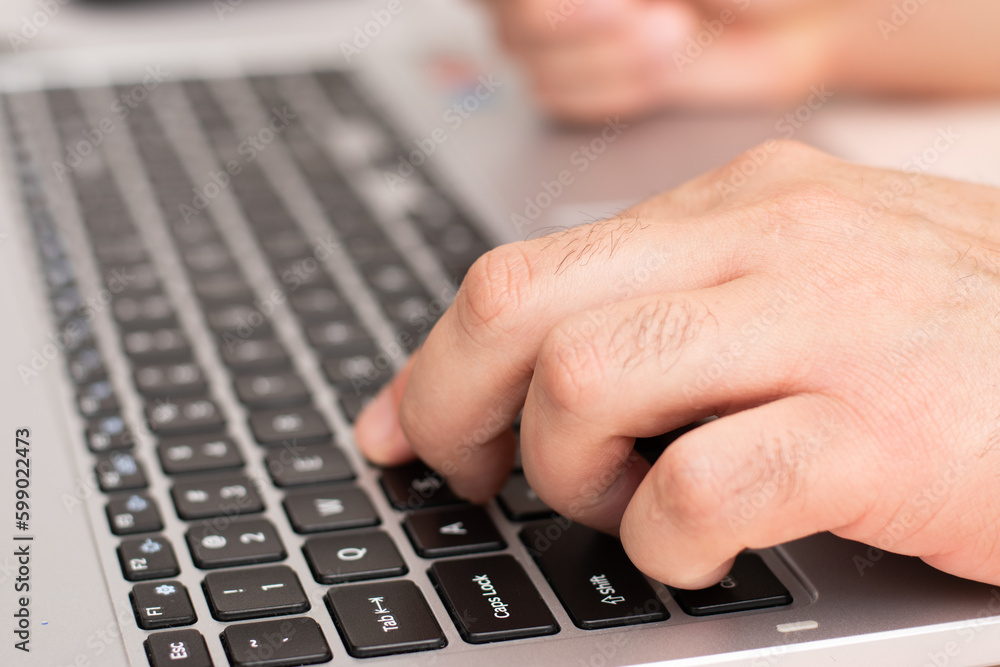 First plane of hand typing in keyboard of laptop with copy space First plane of hand typing in keyboard of laptop with copy space