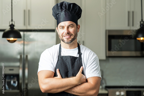 Man in chef apron cooking on kitchen.
