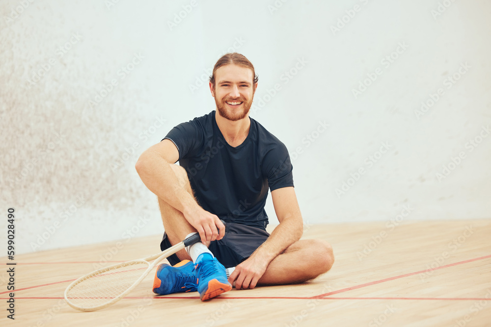 Portrait of young athletic squash player taking break after playing court game with copyspace. Full length of one smiling caucasian athlete sitting after training practice in sports centre. Fit activ Portrait of young athletic squash player taking break after playing court game with copyspace. Full length of one smiling caucasian athlete sitting after training practice in sports centre. Fit activ