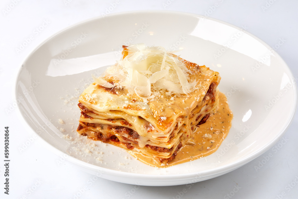 Traditional lasagna with bolognese sauce topped with basil leaves