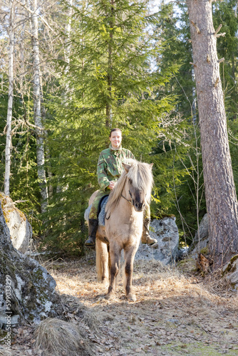 Icelandic horse and camouflaged woman in Finnish spring enviroment