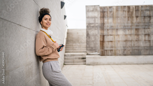 Portrait young caucasian woman stand in front of modern concrete wall