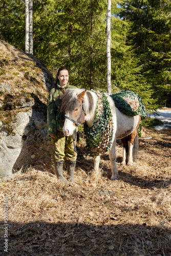 Camouflaged icelandic horse and woman in Finnish spring enviroment