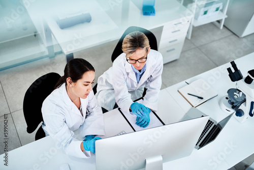 Using clinical trials and investigative methods to reach their findings. two scientists working together on a computer in a lab.