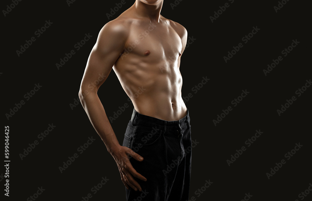 Fototapeta premium Silhouette of a slender muscular man doing sports in the gym. Sports and healthy lifestyle.