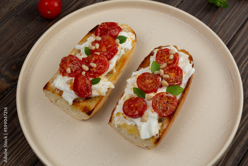 Bruschetta with dried tomatoes and strachatella cheese Bruschetta with dried tomatoes and strachatella cheese