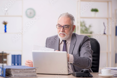 Old male employee working in the office