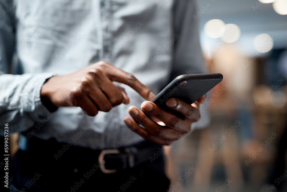 Phones are made for so much more than just talking. an unrecognisable businessman using a smartphone in a modern office.