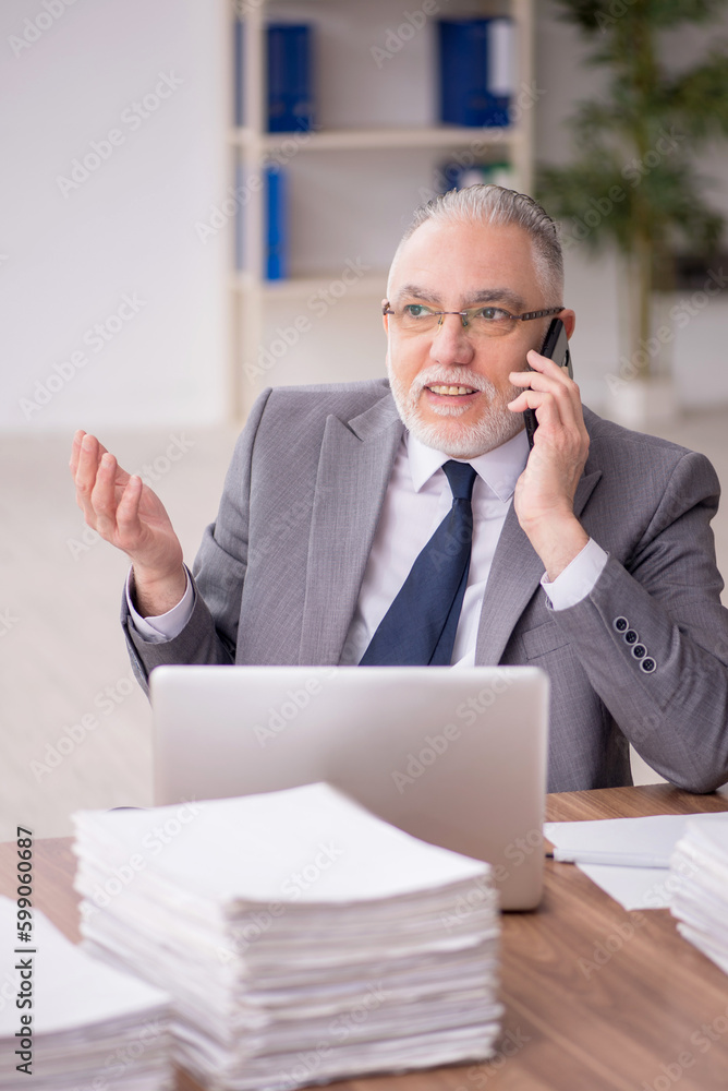 Old male employee and too much work at workplace Old male employee and too much work at workplace