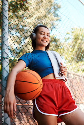 Ill show you my skills on the court. Portrait of a sporty young woman holding a basketball while standing against a fence outdoors. © C Malambo/peopleimages.com
