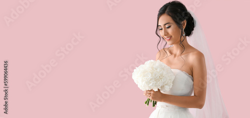 Beautiful young Asian bride on pink background with space for text