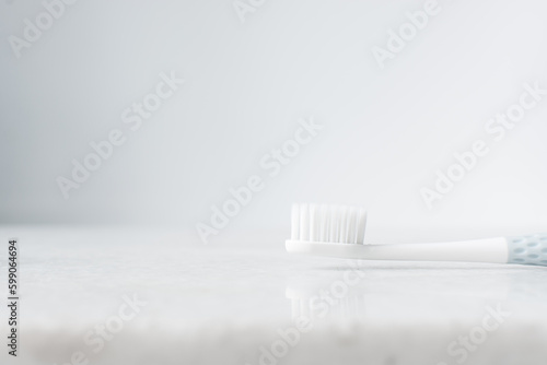 Pastel blue toothbrush with white bristles on a white background  Pastel blue toothbrush with copy space