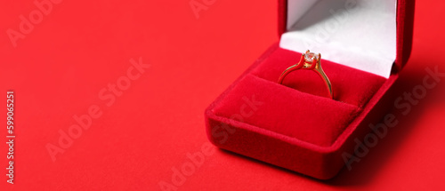 Box with engagement ring on red background with space for text, closeup