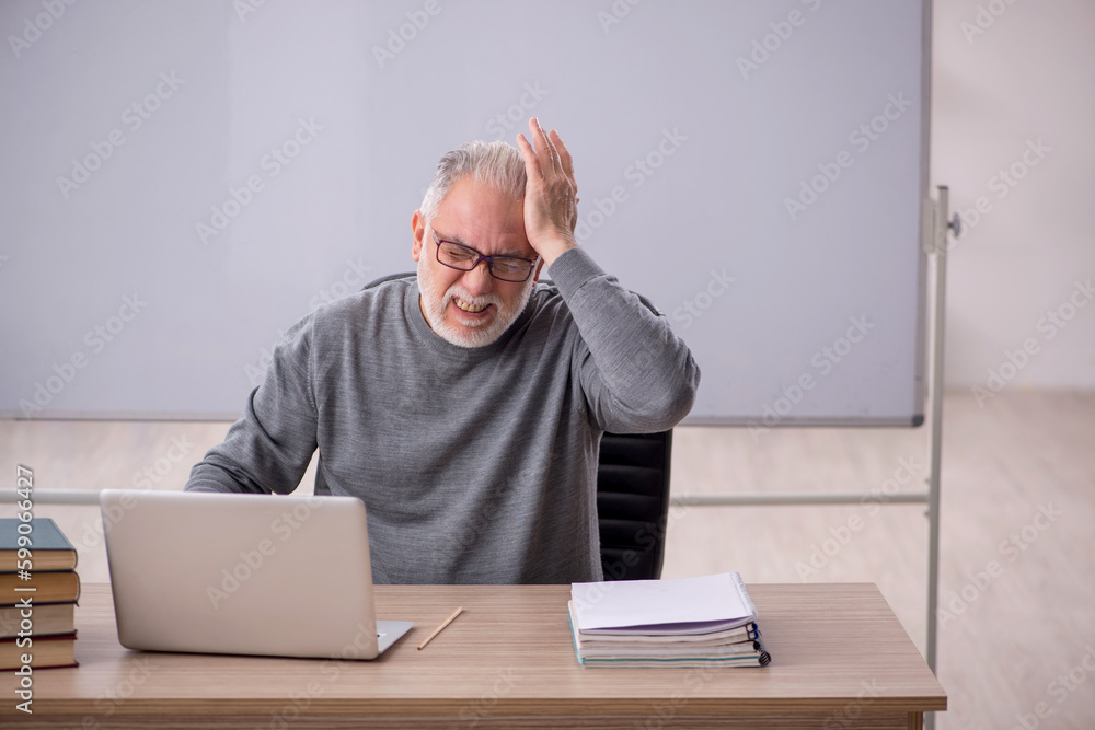 Old male doctor feeling bad in the classroom Old male doctor feeling bad in the classroom