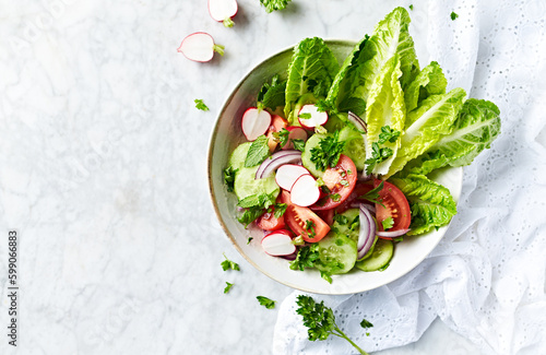 Spring salad with tomato, lettuce, cucumber and radishes. Copy space. Top view