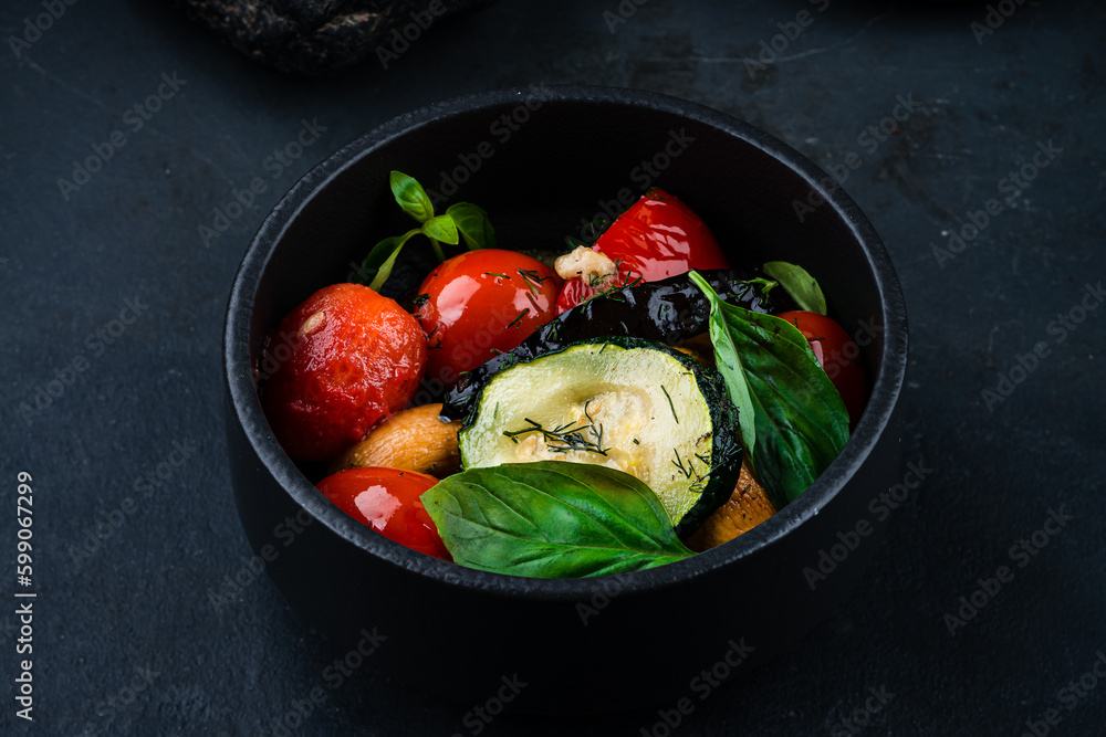 Garnish pickled vegetables zucchini, eggplant, tomatoes with spices and herbs in a bowl.