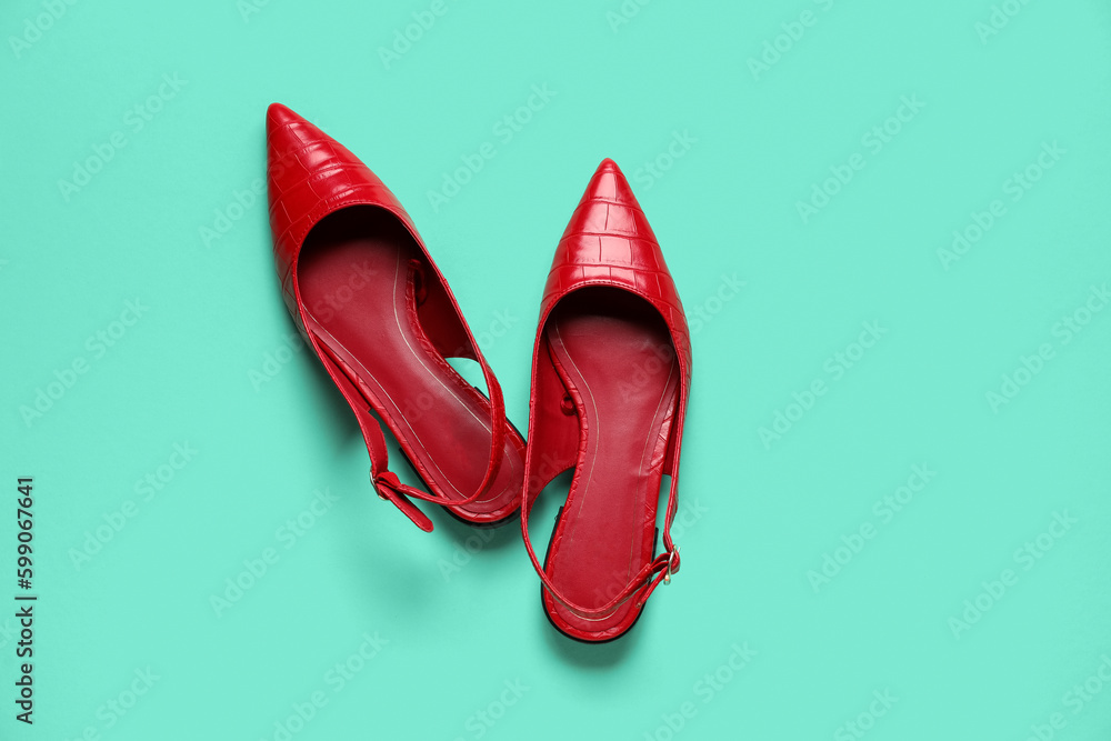 Pair of stylish red shoes on color background