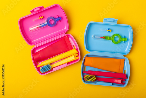Oral care.Travel set with a toothbrush, toothbrush and toothpaste in a case.Composition on a textural yellow background. Dentist concept. Flat lay. copy space.Place for text
