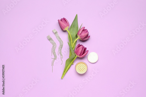 Composition with beautiful earrings, makeup powder and tulip flowers on lilac background
