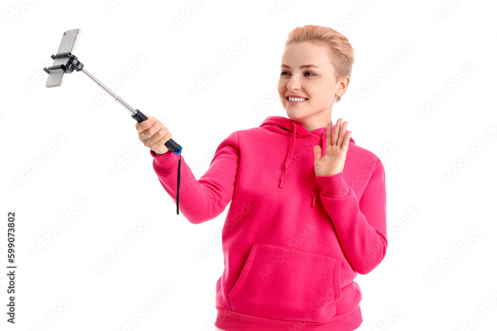 Young woman with mobile phone taking selfie on white background Young woman with mobile phone taking selfie on white background