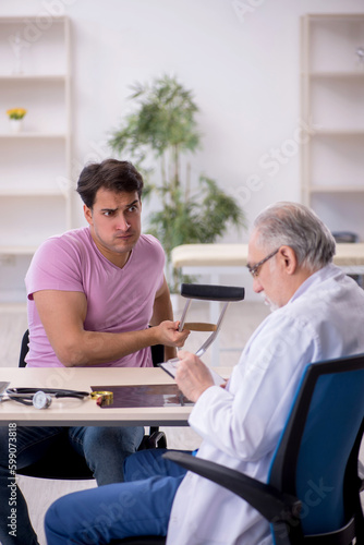 Young leg injured patient visiting old male doctor