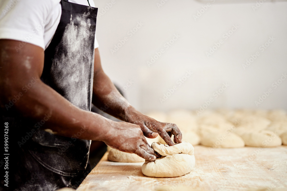 After rolling these up Ill let then sit for a few minutes. a male baker busy shaping dough at work.