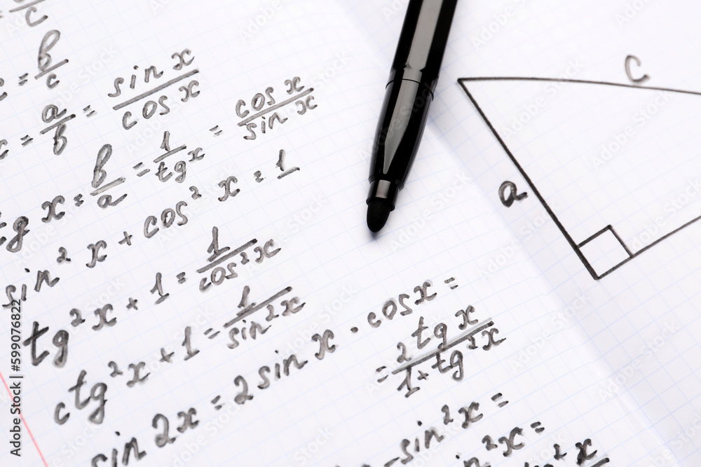 Copybook with maths formulas and pen, closeup Copybook with maths formulas and pen, closeup