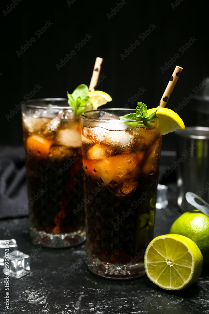 Glasses of cold Cuba Libre cocktail on dark background Glasses of cold Cuba Libre cocktail on dark background