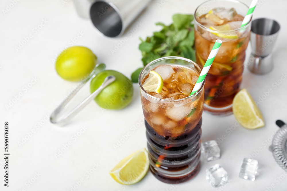 Glasses of cold Cuba Libre cocktail on light background Glasses of cold Cuba Libre cocktail on light background